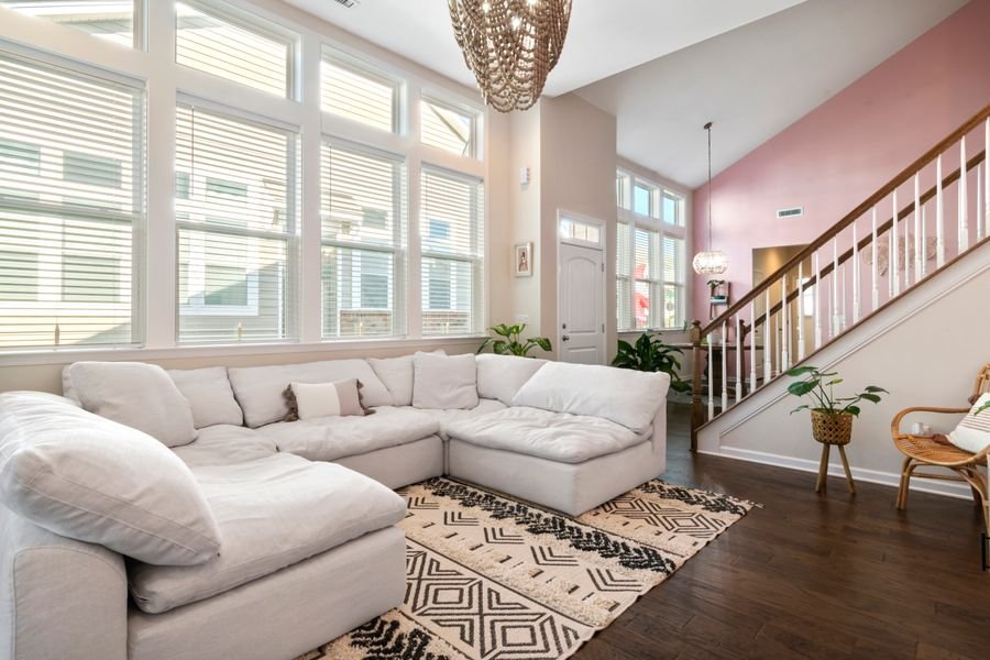Bright, airy living room with tall windows and a neutral sectional sofa